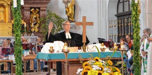 Dekanin Dagmar Häfner-Becker leitet den Gottesdienst am Altar, umgeben von Kerzen und Blumenschmuck. Foto  Otto