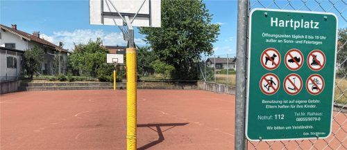 Der Hartplatz der Grundschule Söchtenau mit Basketballkorb und einem Schild, das die Nutzungsregeln und Öffnungszeiten angibt. Foto Peter Böck
