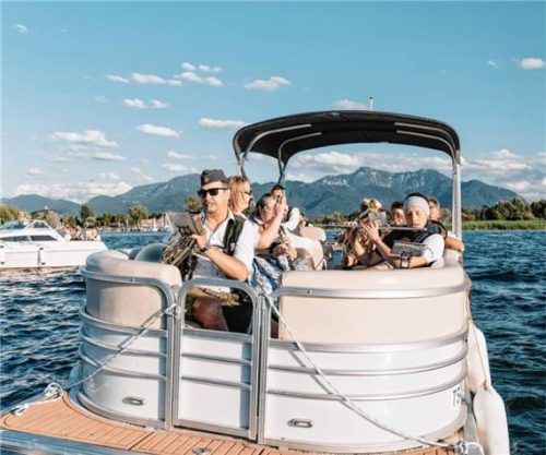 Die Blaskapelle Übersee-Feldwies musiziert auf einem Pontonboot auf dem Chiemsee.