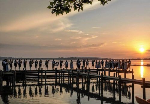 Die Blaskapelle Übersee-Feldwies spielt bei Sonnenuntergang auf einem Steg am Chiemsee. Foto  Gasser