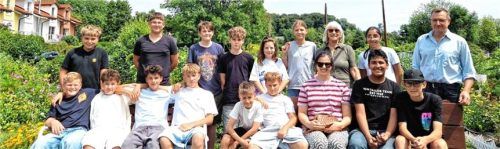 Die siebte Klasse der Chiemsee-Realschule mit ihrer Lehrerin Katrin Hassler (vorne, Dritte von rechts), dem Gemeinderat Ulrich Steiner (hinten rechts) und der Gemeinderätin und Umweltreferentin Angela Kind (hinten, Dritte von rechts) im Gemeinschaftsgarten. Foto Wagner