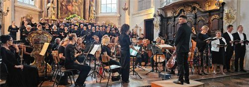 Dirigent Alexander Aigner schaut mit Konzertmeisterin Elisabeth Überacker auf alle Mitwirkenden bei seinem ersten Kirchenkonzert in Mühldorf-St. Nikolaus. Foto Gärtner