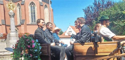 Festlich geschmückt: Klaus Schülein (links) und weitere Geistliche fahren in einer Kutsche während des Primiz-Festzugs. Foto Giesen