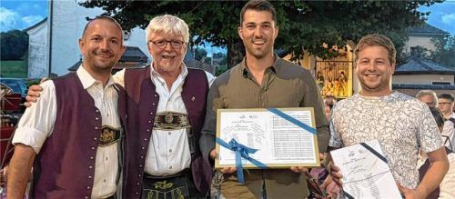 Freundschaftstreffen: Tobias Gasteiger, Vorsitzender des Musikvereins Grassau (von links), und der Komponist Karl Kamml überreichen den Notensatz an den Dirigenten der Trachtenkapelle, Andreas Kapellner, und den Vorsitzenden der Trachtenmusikkapelle Zell am Moos, Manuel Teufel. Foto Marktkapelle Grassau