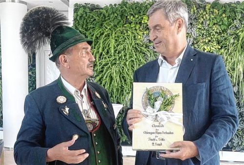 Gauehrenmitglied Anton Hötzelsperger überreicht Bayerns Ministerpräsidenten Dr. Markus Söder ein Exemplar der Chronik. Foto re