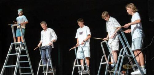 Junge Musiker des Ensembles „Monsters Of Groove“ stehen auf Leitern und spielen Percussion mit Stöcken. Foto Berger