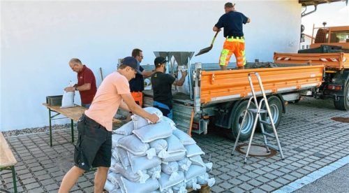 Mitarbeiter des gemeindlichen Bauhofs und der Feuerwehr Grassau füllen Sandsäcke. Diese können jederzeit vor dem Feuerwehrhaus von Grassauer Bürgern abgeholt werden. Foto Eder