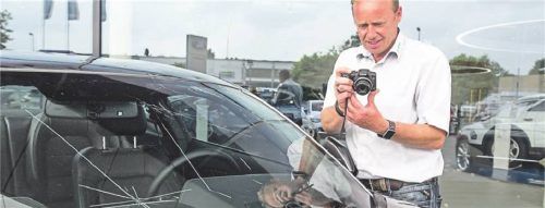 Nach dem Gewitter: Ein Experte begutachtet und dokumentiert den Hagelschaden aneinem Auto. Foto IMAGO