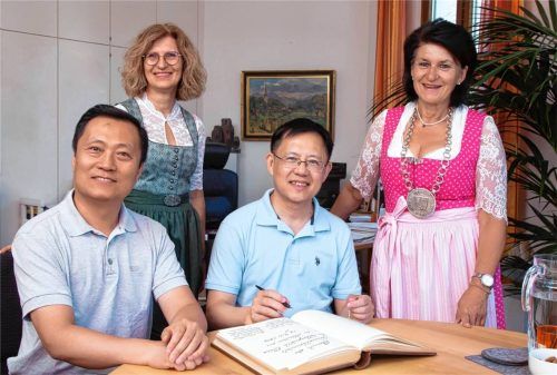 Seltene Gäste: Dr. Liu Qingwen (Mitte) trägt sich im Beisein von Rosi Hell (rechts), Karina Dingler und Ken Liu in das Goldene Buch von Prien ein. Foto Anita Berger