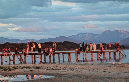Besucher versammeln sich auf dem Steg, um den Sonnenuntergang über dem Chiemsee zu beobachten. Foto Zandl