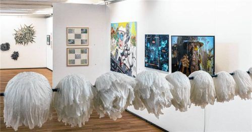 Blick in den Ausstellungsraum der Städtischen Galerie im Kulturforum mit den aufgefädelten Seidenobjekten von Regina Viktoria Schmidt („Kommt noch was?“) im Vordergrund, Arbeiten von Uli Reiter („Ausschweifung“), Inge Kurz („Shadow Stalker“ und „Wunschmaschine“) sowie Christine Grandy-Dick („Landverschiebungen“) an der Wand (von rechts) sowie Senta Strähhubers „Rüsthaus“-Skulpturen an der Wand links hinten. Foto effner
