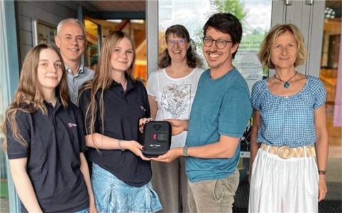 Dr. Matthias Volz vom „Kids Save Lives“-Team (Zweiter von rechts) übergibt einen Schulungsdefibrillator (AED) an das Erste-Hilfe-Team des Gymnasiums. Foto Chiemgau-Gymnasium