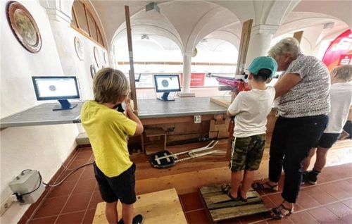 Ein Bub wird beim Schießen mit dem Lichtgewehr am Schießstand betreut. Foto Hötzelsperger