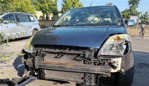Ein Schrottauto mit platten Reifen, demolierter Stoßstange, zerborstener Windschutzscheibe und verbeultem Blech steht auf dem Parkplatz am Bad Aiblinger Friedhof. Foto Kotter
