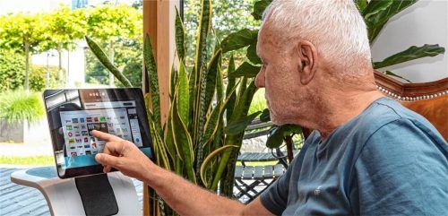 Ludwig Winklmaier interagiert mit einem Tablet bei einem Pressetermin. Fotos Regnauer Hausbau