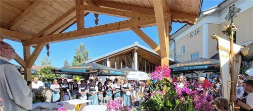 Ortspfarrer Andreas Przybylski zelebriert den Festgottesdienst, umgeben von blühenden Blumen und den Frauen der Christlichen Frauenbewegung Eggstätt.