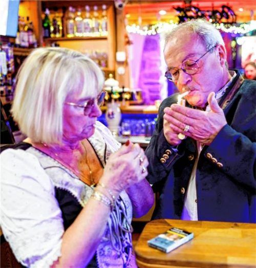 Peter Krall, Inhaber des „Hofbräu Raucher Stüberl“, und seine Schwester Birgit zünden sich am Tresen des Lokals eine Zigarette an. Foto dpa