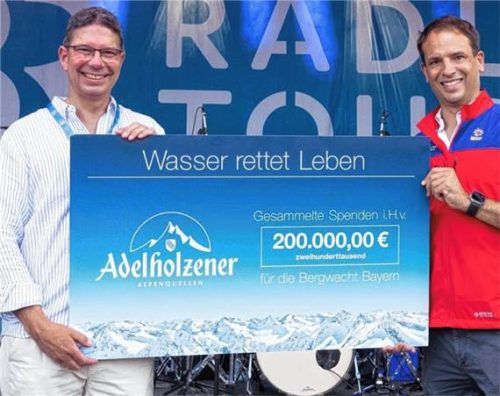 Peter Lachenmeir, Geschäftsführer der Adelholzener Alpenquellen (links), übergibt den Scheck an Dr. Tobias Reploh, stellvertretender Vorsitzender der Bergwacht Bayern. Foto BR/Konvalin