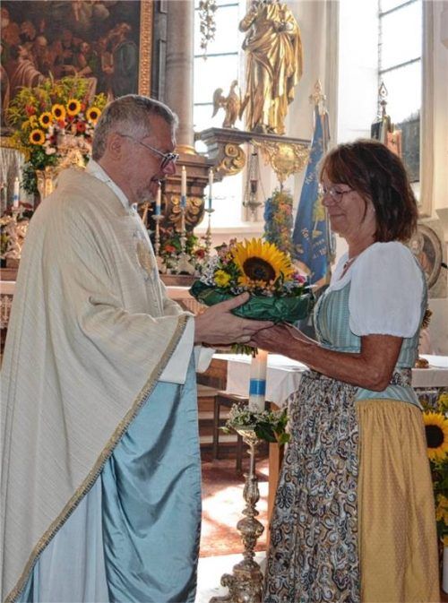 Pfarrer Andreas Horn verabschiedet Caroline Zeisberger und überreicht ihr einen Blumenstrauß. Foto Eder