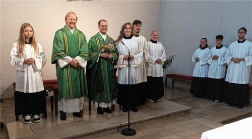 Pfarrer Martin Gehringer, der Dritte von links, freut sich über die Blumen von Lucia Wauer, der Vierten von links. Diakon Bernhard Kinne, der Zweite von links, und alle Ministranten freuen sich mit. Foto  Ruprecht