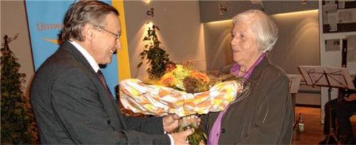 Sylvester Dufter, damaliger Vorsitzender, überreicht Maria Eschenbeck 2009 einen Blumenstrauß zur Ernennung als Ehrenvorsitzende. Foto Forum Ökologie Traunstein