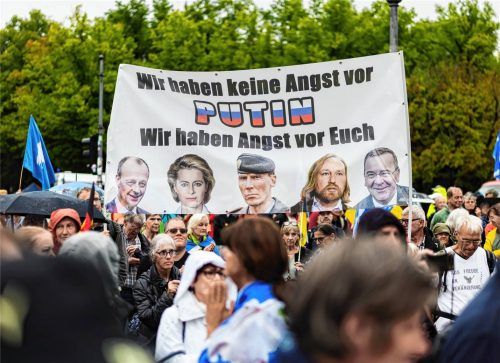 Teilnehmer einer Demonstration des Bündnisses „Wir sind viele“ protestieren vor dem Brandenburger Tor unter dem Motto „Auf nach Berlin für Frieden, Freiheit, Grundrechte und echte Corona-Aufarbeitung“. Auf einem Banner unter anderem mit dem Foto des Bundeskanzlers ist zu lesen „Wir haben keine Angst vor Putin. Wir haben Angst vor Euch“. Foto dpa