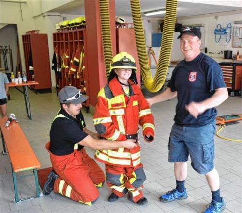 Übergröße: Ein Bub probiert Feuerwehrbekleidung an. Foto  Wunderlich
