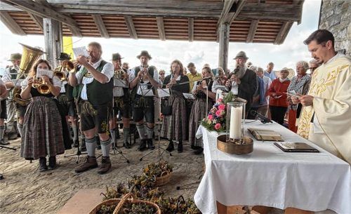 Während des Gottesdienstes auf dem Hochfelln spielen die Miesenbacher Musikanten, während Pfarrer Andrei Mirt die Kräuterbüschel segnet. Foto Helmberger