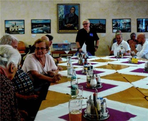 Ani Pitsch (stehend im Hintergrund) begrüßt die zahlreichen Gäste beim unterhaltsamen VdK-Spielenachmittag im Café des Adalbert-Stifter-Heims. Erika Fischer