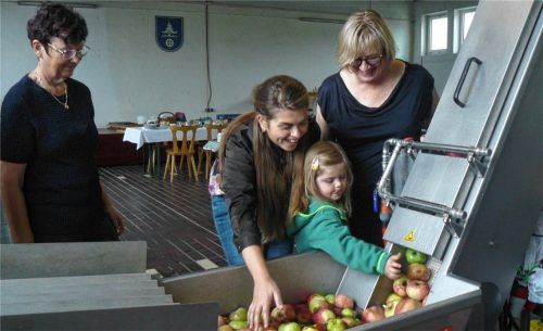 Beim Apfelwaschen voll in Aktion: (von links) Zweite Bürgermeisterin Stephanie Pollmann mit ihrer kleinen Tochter und Enikö Döring. Fischer
