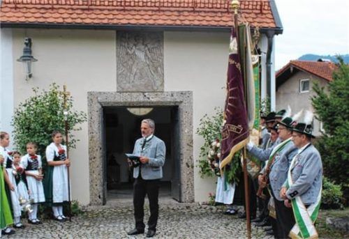 Dankbarkeit und Zusammenhalt stellte Andreas Mayer (Mitte), Vorsitzender des GTEV „Alpenrose“ Nußdorf, beim Totengedenken in den Mittelpunkt seiner Ansprache. Links Pfarrer Christoph Rudolph, rechts die Fahnenabordnungen des Patenvereins aus Raubling und der Nußdorfer Trachtler. Volkhard Steffenhagen