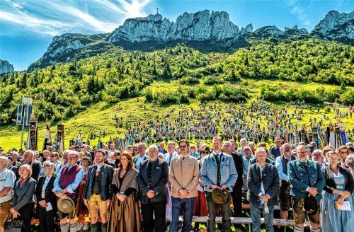 Eine eindrucksvolle Kulisse zwischen Altar und Gipfelkreuz: der Blick über die Ehrengäste, Hunderte Gläubige und zahlreiche Vereinsfahnen bis hinauf zum Chiemgau-Kreuz, das seit 75 Jahren auf dem Kampenwandmassiv thront. Nitzsche