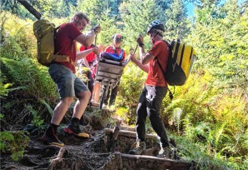 Eine gestürzte Wanderin wurde mit der Gebirgstrage zur Wache der Bergwacht gebracht. Bergwacht Rosenheim-Samerberg