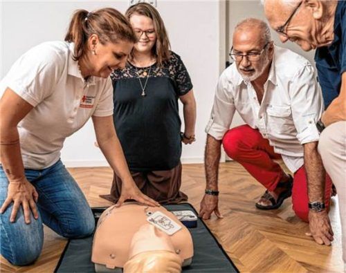 Eine Gruppe von Teilnehmenden übt die Herz-Lungen-Wiederbelebung an einer Trainingspuppe. BRK Rosenheim