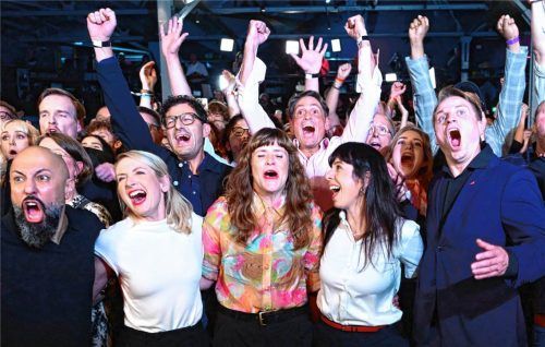 Elif Eralp, Spitzenkandidatin und stellvertretende Vorsitzende der Berliner Linksfraktion (vorne, Zweite von rechts), und Anhänger der Linken freuen sich auf einer Wahlparty im Festsaal Kreuzberg über die Prognose zum Ergebnis der Abgeordnetenhaus-Wahl. dpa