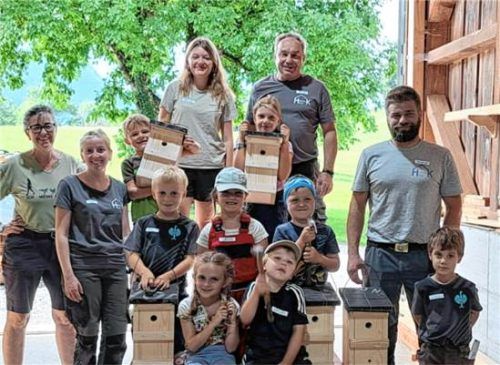 Kinder und Betreuer beim Ferienprogramm des Obst- und Gartenbauvereins Samerberg mit selbst gebauten Nistkästen aus Holz in einer Zimmerei-Werkstatt.  Deindl