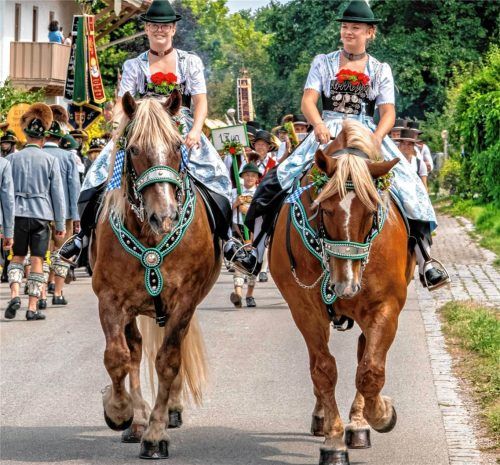 Trachtentradition hoch zu Ross: Lisa (links) und Veronika Auer führen auf ihren festlich geschmückten Pferden den Jubiläumsfestzug des GTEV „Hochries-Samerberg“ durch Grainbach an.  Nitzsche