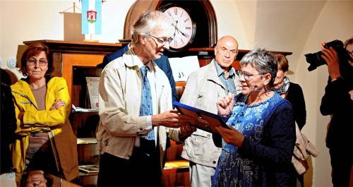 Waldkraiburgs Stadtarchivar Konrad Kern überreicht Kulturamtsleiterin Dr. Renata Mauserová bei der Ausstellungseröffnung ein gerahmtes Bild.Stadt Waldkraiburg