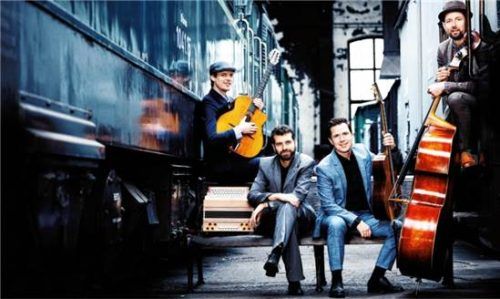 Das Diknu Schneeberger & Bakanic Quartett posiert mit seinen Instrumenten vor einem Zug. Christoph Lehner