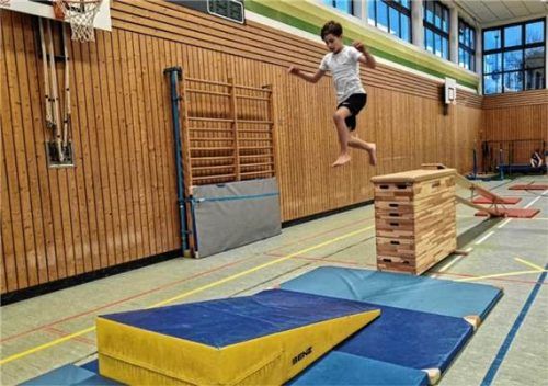 Ein Junge springt in der Turnhalle über Hindernisse beim Parkour- und Freerunning-Training. Tourist-Info Frasdorf