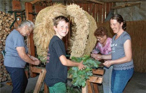 Fleißige Helfer beim Anfertigen der traditionellen Erntekrone vor dem Fest. Thomas Schwitteck