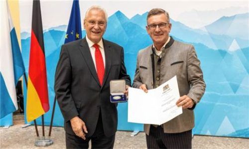 Innenminister Joachim Herrmann (links) überreicht dem ehemaligen Samerberger Bürgermeister Georg Huber die Kommunale Verdienstmedaille in Silber samt Urkunde. Bayerisches Innenministerium / Alexandra Beier