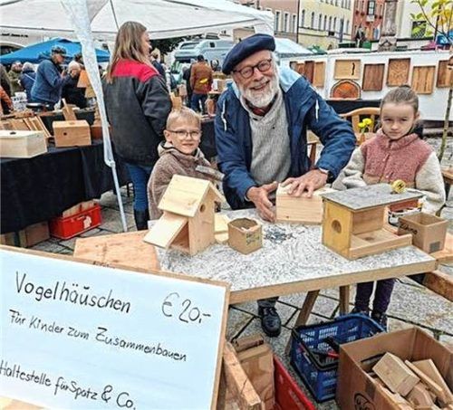 Kunstschreiner Joachim Bederke hilft jungen Besuchern dabei, Vogelhäuschen zusammenzubauen.  Oberkandler